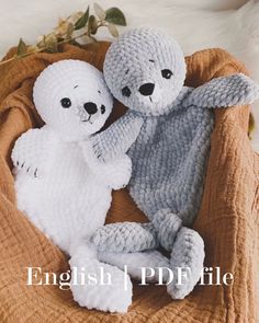 two crocheted stuffed animals sitting on top of a blanket