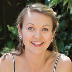 a woman with blue eyes is smiling for the camera