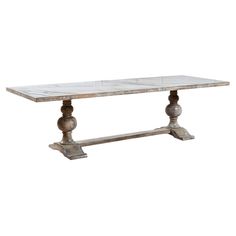 a marble top dining table with two wooden pillars on each end and an ornate base