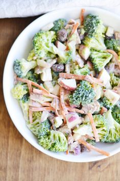 broccoli apple salad in a white bowl on a wooden table with text overlay