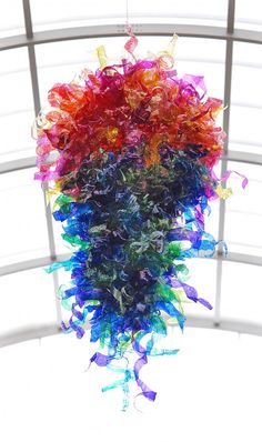 a multicolored piece of art hanging from a ceiling