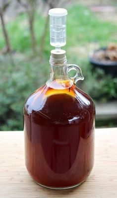 a glass bottle filled with liquid sitting on top of a wooden table