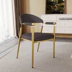 a black and gold chair sitting in front of a white dresser