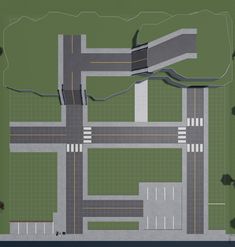 an aerial view of a street intersection in the middle of a green area with trees