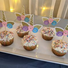 cupcakes decorated with colorful frosting and sprinkles on a plate