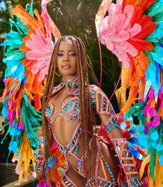 a woman with long dreadlocks and colorful feathers