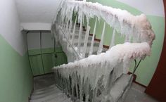 the stairs are covered with ice and icicles in this house's entry way