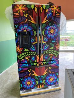 a colorful painted refrigerator sitting on top of a tiled floor