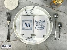 two napkins on a plate with silverware and wine glasses next to them,