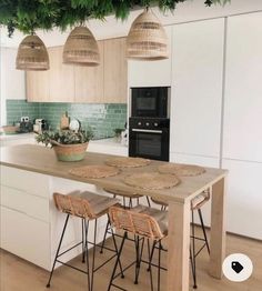 an island in the middle of a kitchen with wicker stools