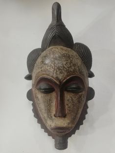 an african mask hanging on the wall