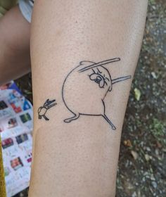 a person with a tattoo on their arm has a drawing of a cartoon character holding a baseball bat