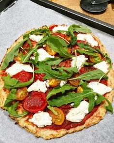 a pizza sitting on top of a pan covered in cheese and veggie toppings