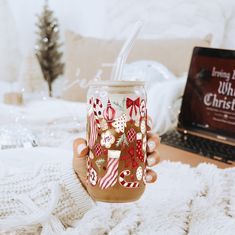 a person holding a mason jar with christmas decorations on it