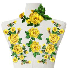 a white mannequin with yellow flowers and green leaves on it's neck