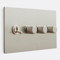 a close up of a light switch with four knobs and two switches on each side