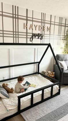 a toddler is sitting on his bed reading a book