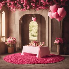 a table with pink heart shaped balloons hanging from it's ceiling and flowers in the background