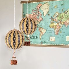 two paper lanterns hanging from strings in front of a map