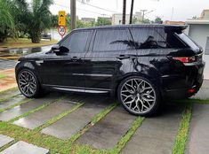 a black range rover parked in front of a house