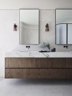 a bathroom with two sinks and mirrors on the wall