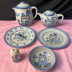 four pieces of blue and white pottery on a pink tablecloth