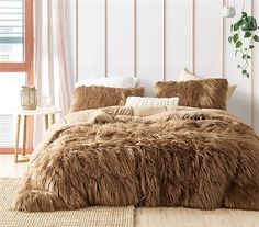 a large furry bed with pillows and blankets