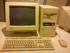 an old desktop computer sitting on top of a table next to a keyboard and mouse