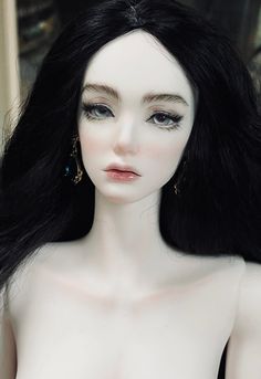 a close up of a mannequin with long black hair and earrings on it's head