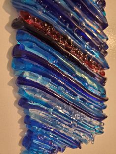 there are many blue and red toothbrushes lined up in the shape of a wave