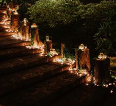 candles are lit on the steps leading up to some trees