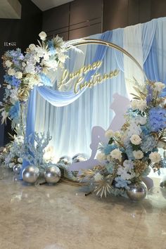 a blue and white wedding backdrop with flowers