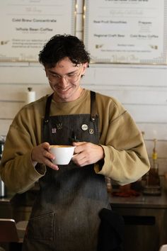 a man in an apron holding a coffee cup