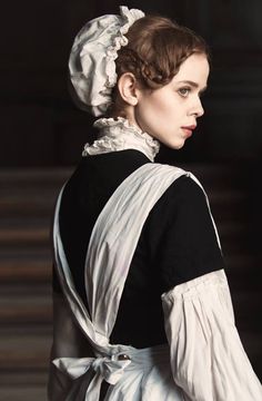 a woman in black and white dress with a large ruffle on the back of her head