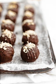 there are chocolates with nuts on top of them in the tray, ready to be eaten