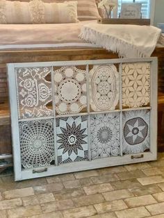 a bed sitting next to a window covered in doily