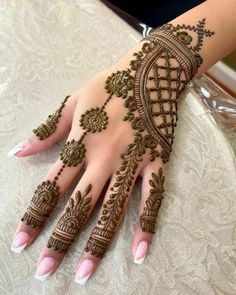 a woman's hand decorated with henna and intricate designs on her hands,