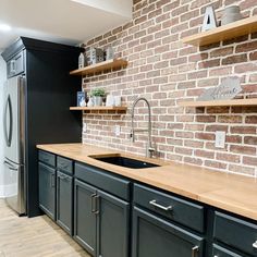 a kitchen with brick walls and black cabinets