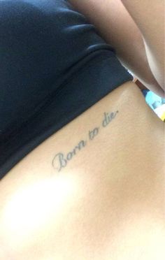 a woman's stomach with the words born to die tattooed on her lower back