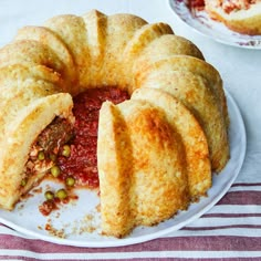 a deep dish meat pie on a white plate with a red and white striped tablecloth