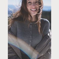 a smiling woman with her arms crossed in the snow