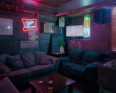 a living room filled with furniture and neon signs