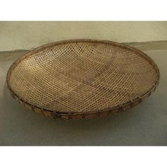 a woven basket sitting on top of a cement floor