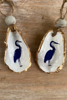 two pieces of shell with blue and white designs on them sitting on a wooden surface