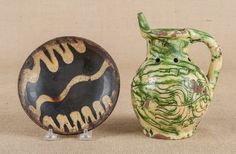 two vases sitting next to each other on top of a cloth covered flooring