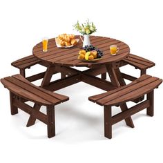 a wooden picnic table with two benches and plates of food on the table next to it