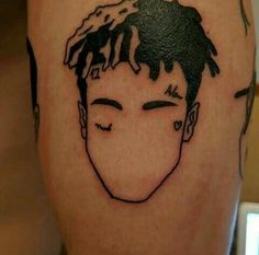 a man's face is drawn on the side of his leg with black ink