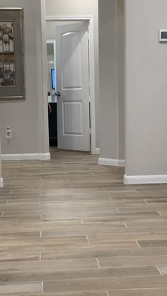 an empty hallway in a home with wood floors and white trim on the door way