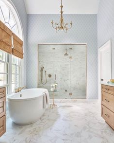 a large white bath tub sitting inside of a bathroom next to a walk in shower