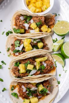 slow cooker tacos al pastora on a white plate with lime wedges